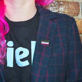 An asexual pin on the lapel of a woman