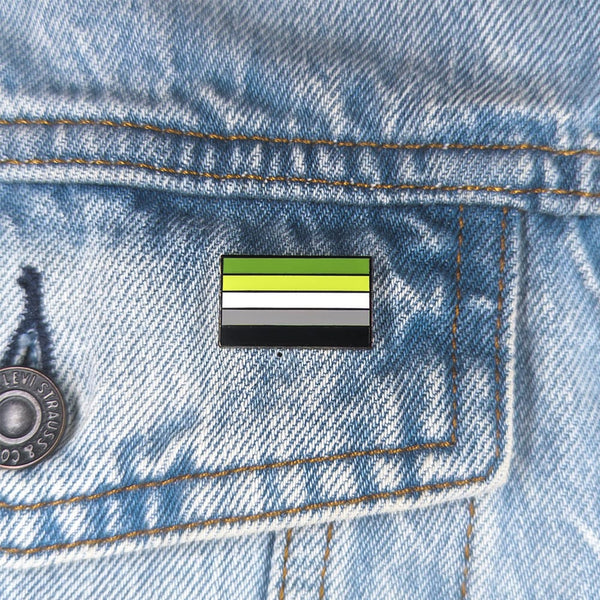 Close up image of an aromantic pin on a denim jacket pocket