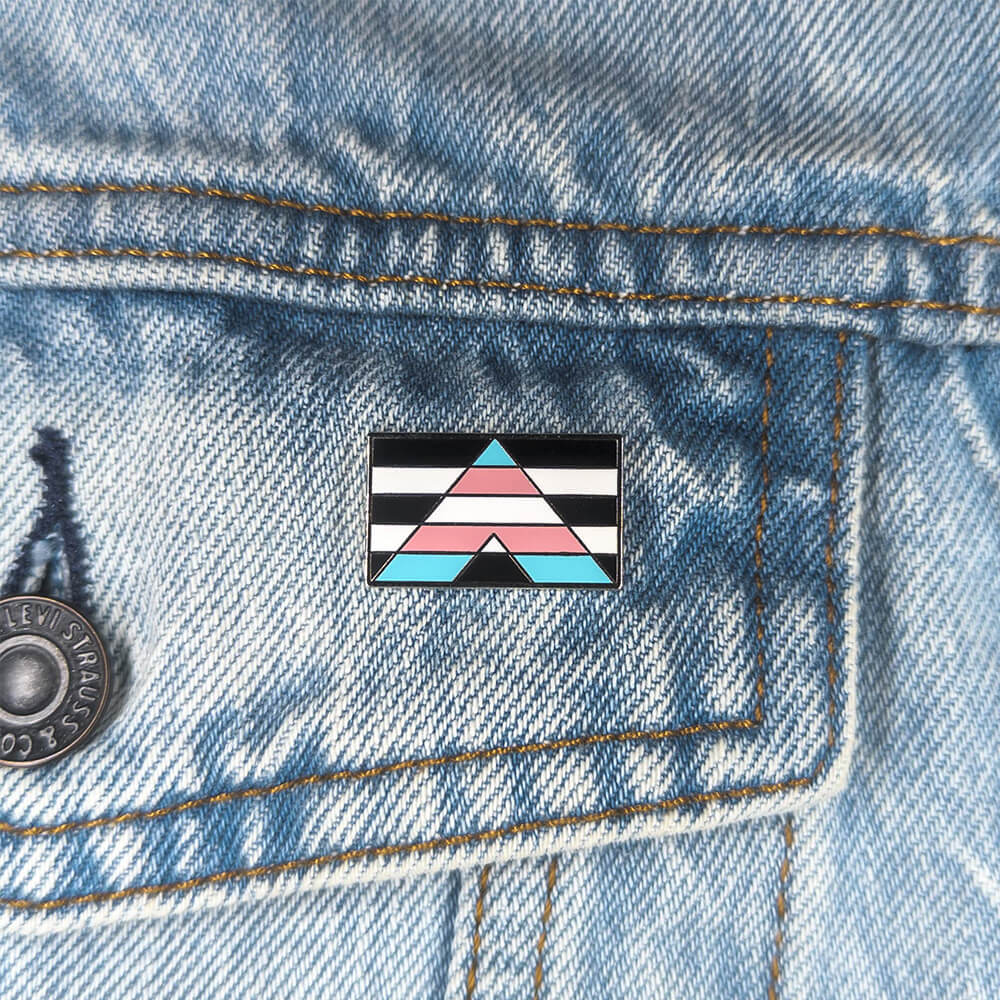 An image of a transgender ally pin on a denim jacket pocket
