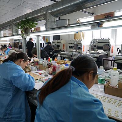 Workers working at the pin manufaturing factory