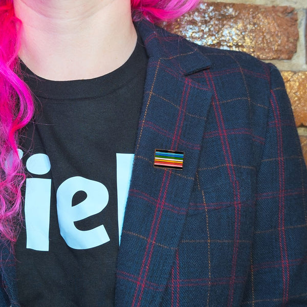 A queer pin on the lapel of a woman